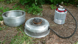 Picture of Gas burner in Trangia base with upper windshield beside